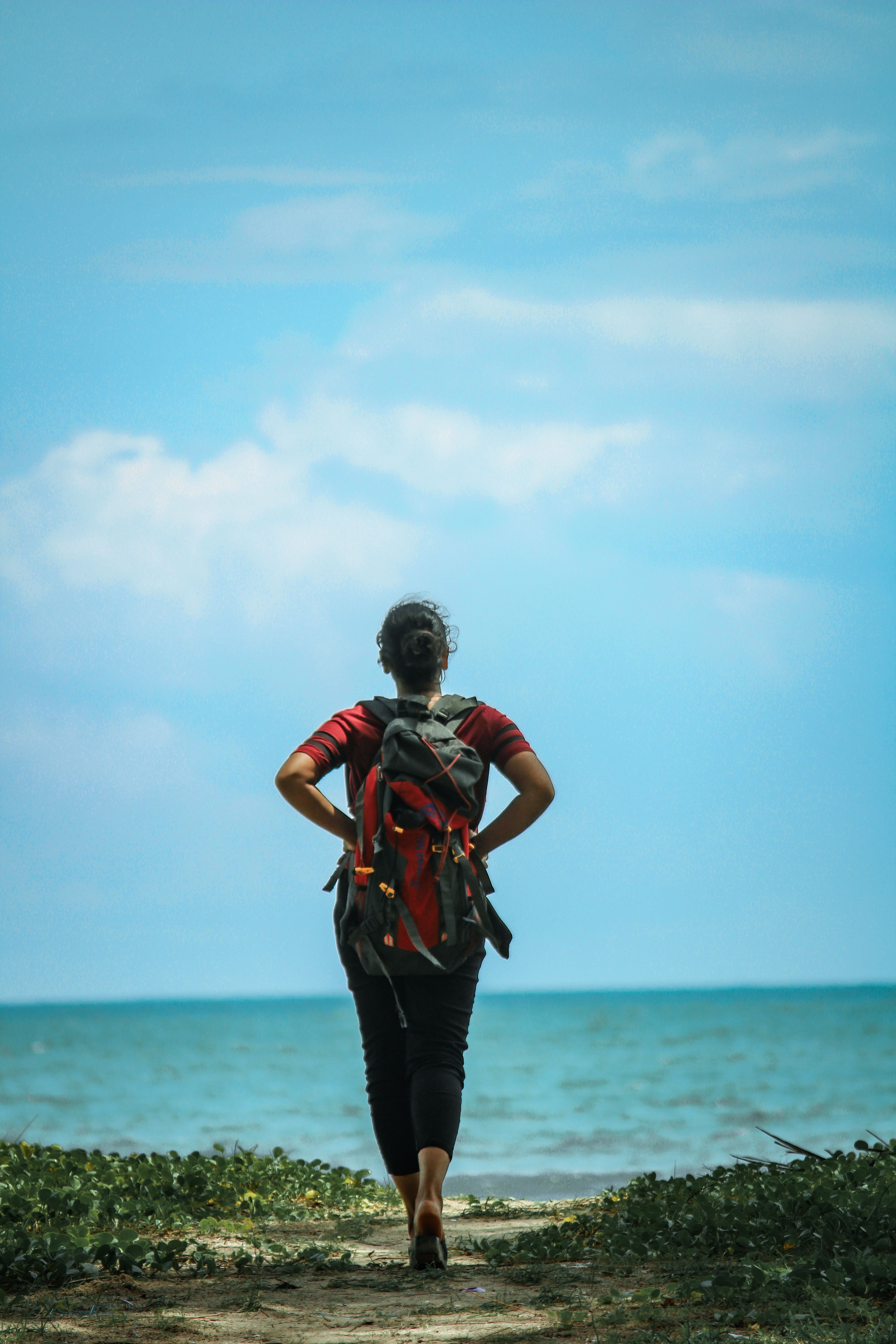A traveler walking toward the coast with a backpack