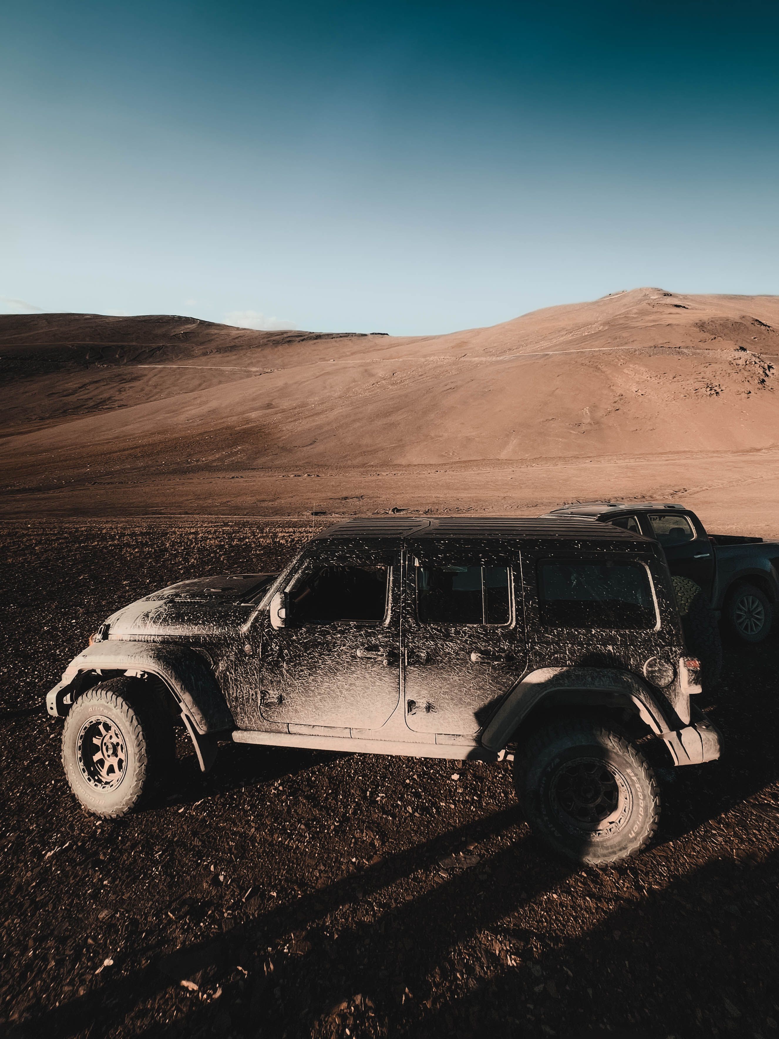 An off-road vehicle in a wide desert landscape