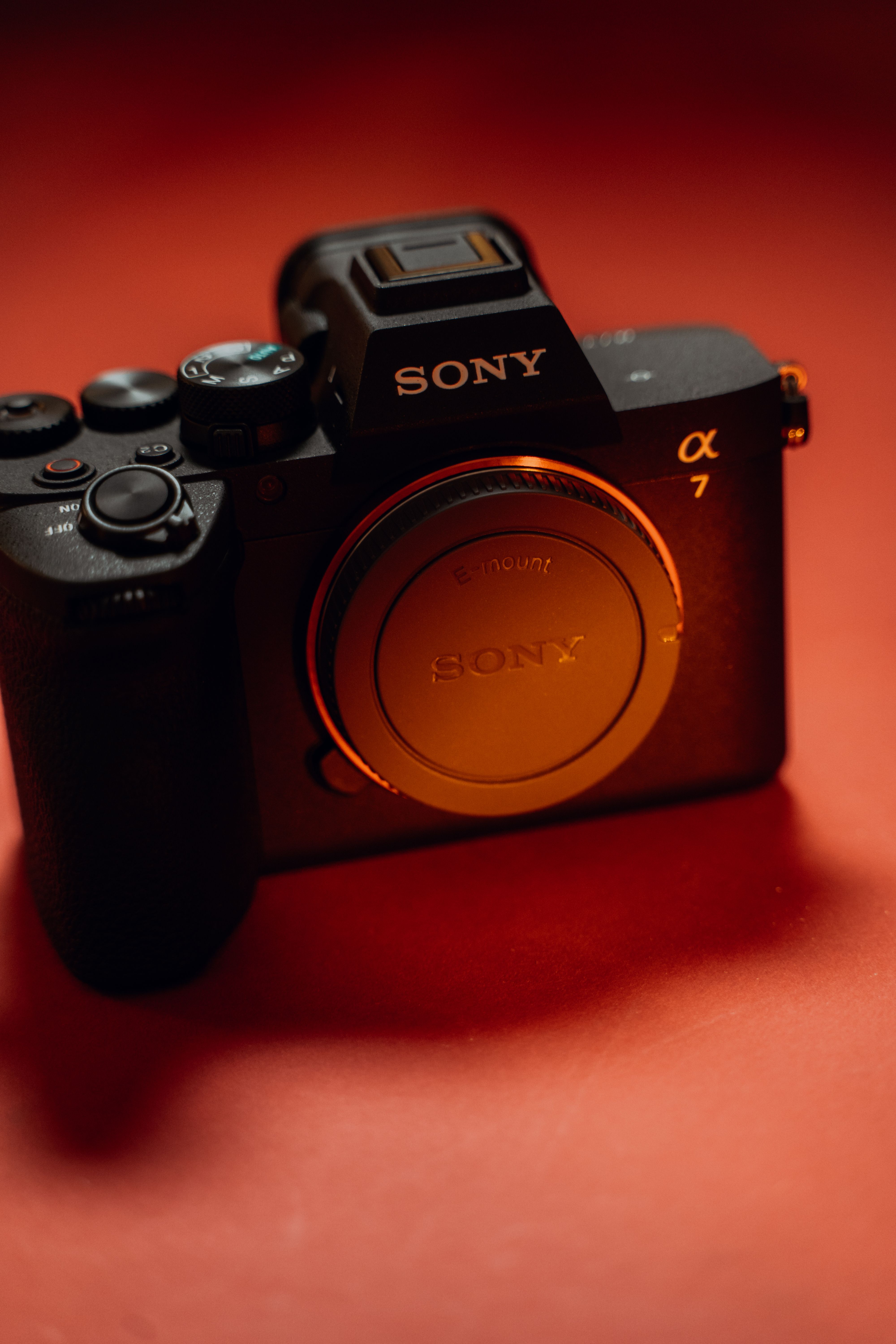 A close-up of a camera against warm red light
