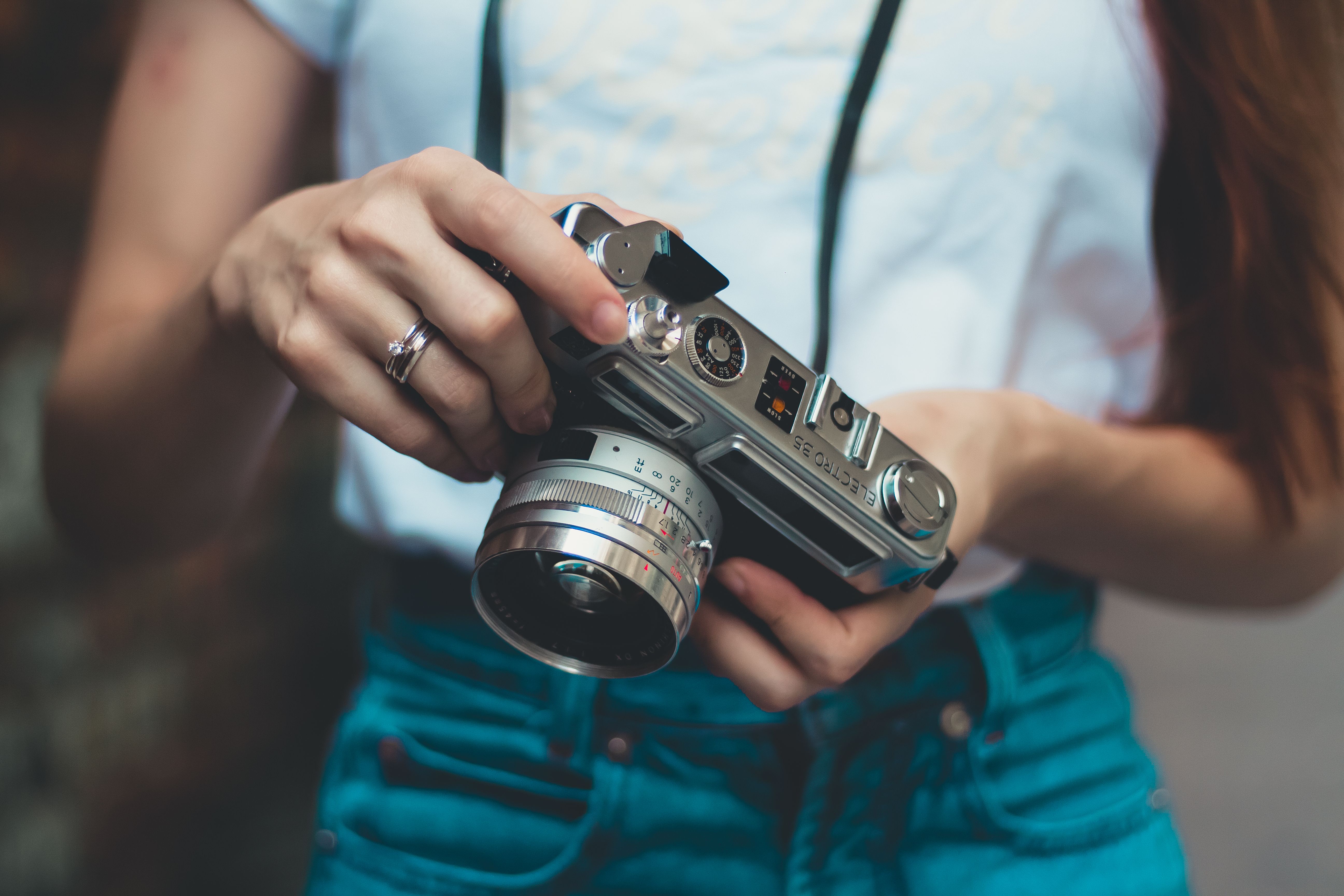 Hands adjusting a retro film camera